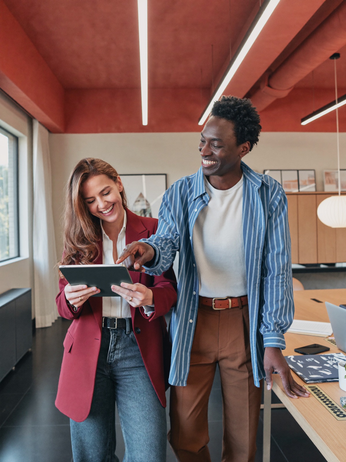 Twee partners bekijken samen lachend een tablet
